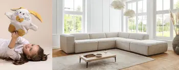 Kleines Kind pielt mit Plüschtier. Großes Ecksofa im hellen natur durchleuchteten Raum mit kleinem Couchtisch.